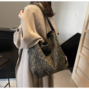 Detail of trendy leopard print tote bag with spacious design and red brand label