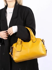 Close-up of bright yellow lychee grain leather handbag with golden hardware