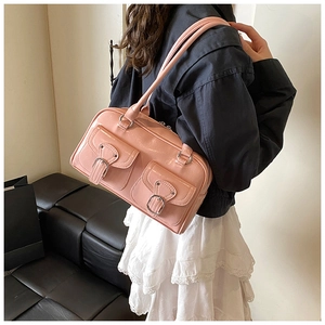 Pink glossy leather shoulder bag featuring cargo style pockets and slim straps shown on model