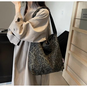Close-up of leopard print tote bag with durable canvas fabric and red side label