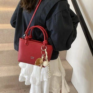 Red lychee pattern leather tote bag with unique baseball glove charm and silver text detail