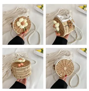 Detailed views of handmade beige straw round bag with 3D fabric flower and pearl strap