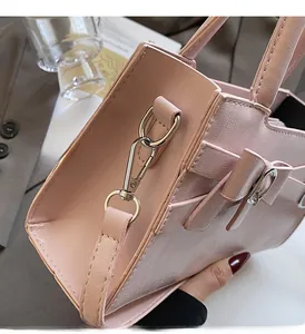 Detail view of pink leather handbag showing glossy texture and silver hardware accents