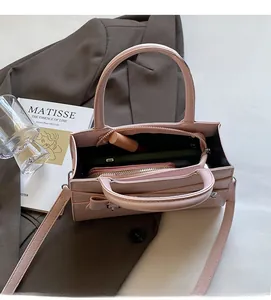 Top view of pink minimalist square handbag showing interior space with phone and wallet