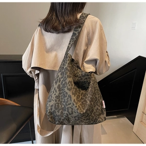 Detailed shot of leopard print canvas tote bag on trench coat showing texture and size