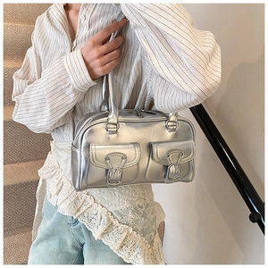 Detail view of silver metallic large tote bag with buckle pockets on office staircase