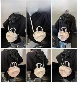 Detail shots of model wearing heart-shaped crossbody bag with bow and leather texture