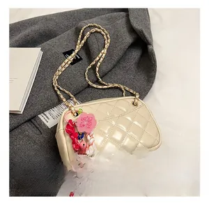 Detail of cream quilted chain bag with floral charms and glossy finish
