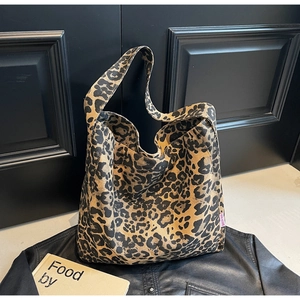 Detailed view of leopard print canvas tote bag on a leather jacket with clear pattern texture