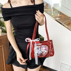 Detail of red heart-shaped ita bag with transparent window and lace ribbon decoration