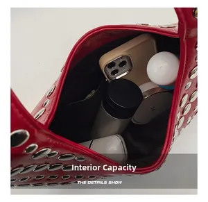 Vue intérieure du sac rouge clouté montrant l'espace pour les objets du quotidien