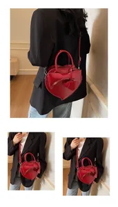 Detailed views of red heart-shaped patent leather crossbody bag with a large bow decoration