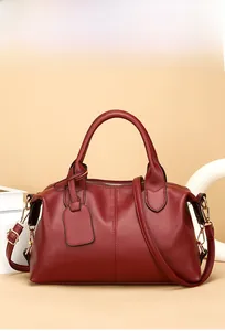 Close-up of burgundy pebbled leather tote bag with gold hardware and shoulder strap