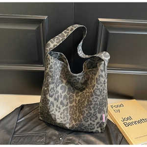 Detail of leopard print canvas tote bag with pink brand label and spacious design