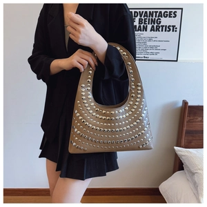 Détail du sac hobo en similicuir marron avec rivets argentés et forme en demi-lune