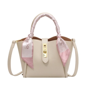 Sac seau crème élégant avec fermoir doré et poignée décorée d'un foulard en soie imprimé
