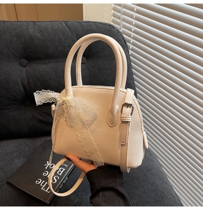 Détails du sac en cuir blanc cassé avec un nœud en dentelle élégant sur l'anse