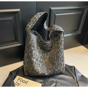 Detail of leopard print canvas tote bag featuring an integrated shoulder strap