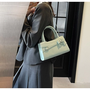 Side view of a mint green crossbody bag worn by a model to show its size and style