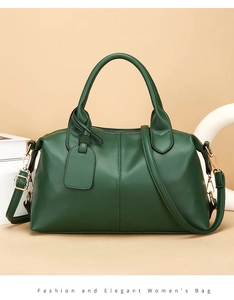 Detailed view of dark green pebbled leather tote with golden hardware and hanging tag