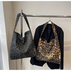 Close-up of leopard print canvas tote bags with red woven label and large capacity design