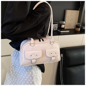 Detail of cream glossy leather pillow bag with silver metal buckles and double pockets