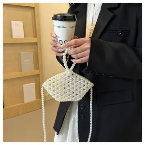 Detailed view of handmade white pearl beaded handbag with unique shell-shaped structure