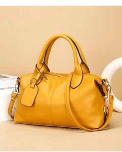 Detail of yellow lychee leather tote bag with golden hardware and detachable strap