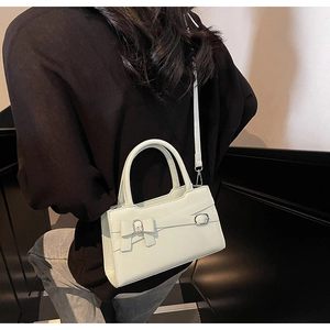 Detail of light mint green crossbody bag featuring a bow accent and silver metal buckle