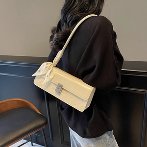 Chic beige textured crossbody bag with silver diamond buckle and decorative silk scarf