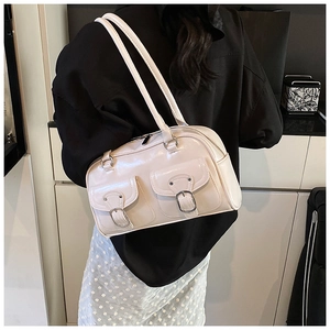 Detail of cream white Boston bag showing side pocket and glossy texture on model
