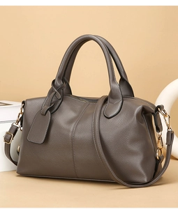 Close-up of elephant gray lychee leather texture and gold hardware on the Boston handbag
