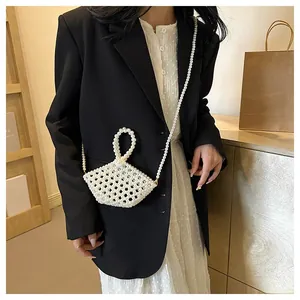 Detail of a handmade white pearl beaded handbag showing intricate weave and crossbody strap