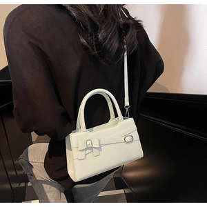 Detail of mint green crossbody bag with silver buckle and bow on model