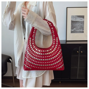 Vue détaillée du sac hobo en cuir rouge avec plusieurs rangées de rivets métalliques