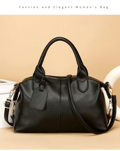 Close-up of black pebble leather handbag featuring gold hardware and adjustable strap