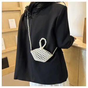 Elegant trapezoid pearl beaded crossbody bag with round handle shown in a home setting