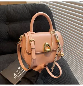 Pink crossbody square bag with U-shaped metal buckle and striped silk scarf detail