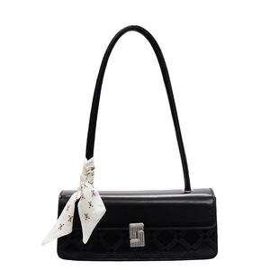 Elegant black leather handbag with sparkling diamond buckle and silk scarf on white background
