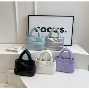 Detail view of five quilted bucket bags in pastel colors with silver chain straps