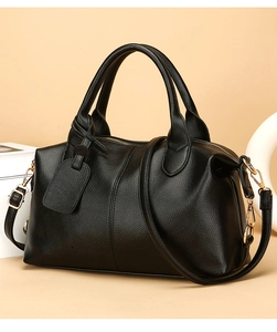 Detail of black pebbled leather texture on a Boston bag with golden zipper and hardware