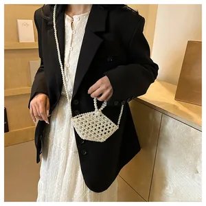 Detail of handmade pearl beaded crossbody bag featuring vintage triangular design and handle