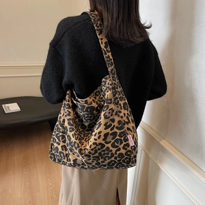 Chic leopard print canvas tote bag with pink label shown on shoulder for daily commute