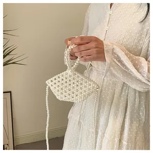 Detail of white handmade pearl beaded handbag with shell shape and crossbody strap