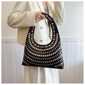 Détail du sac croissant noir avec rivets argentés et finition en cuir brillant chic