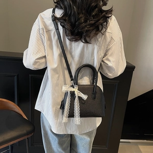 Sac à main noir avec motif litchi, nœud en dentelle et bandoulière réglable
