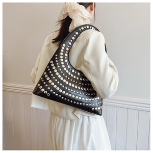 Détail du sac sous le bras noir avec rivets argentés en motif de rayons pour un style Y2K