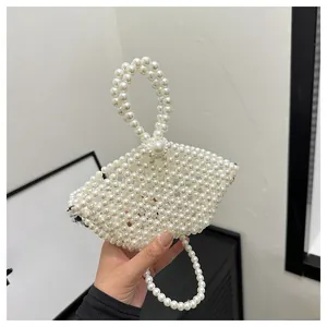 Close-up of handmade white pearl woven handbag with a circular handle and beaded chain
