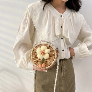 Handmade round straw crossbody bag with floral detail and pearl chain strap