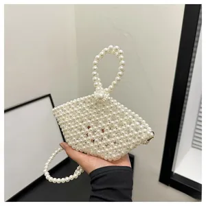 Detail of handcrafted white pearl beaded handbag with elegant top handle and crossbody strap
